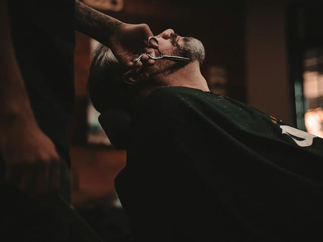 Barber trimming a client's beard