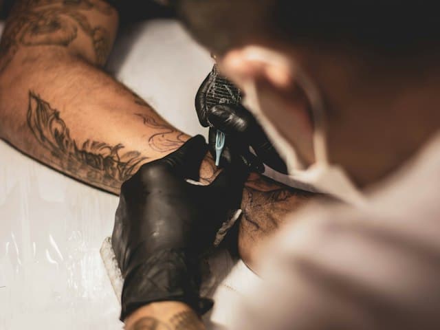 Tattoo artist working on an arm